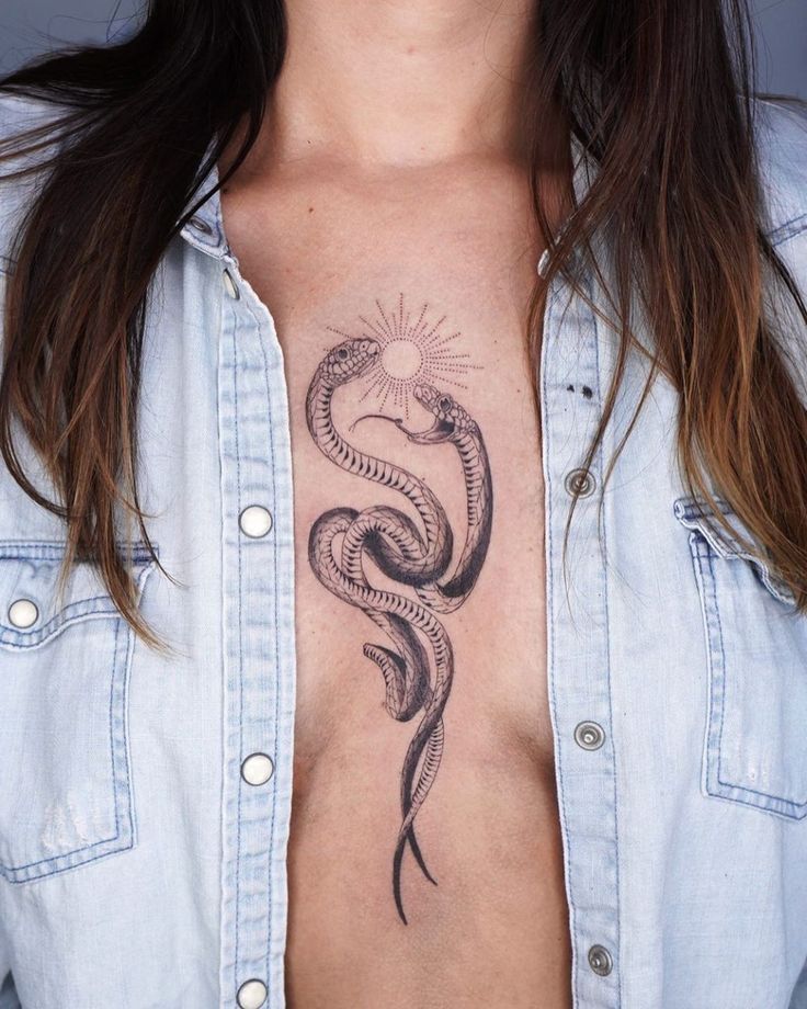 Double snakes breast tattoo