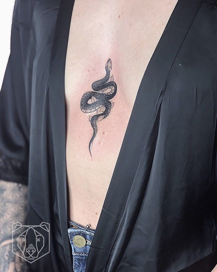 Intricate snake in between breast tattoo