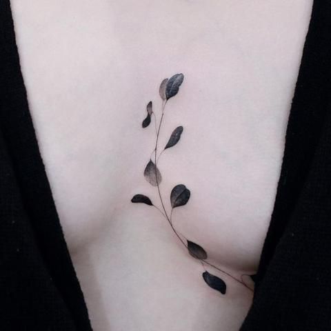 Leaves in between breast tattoo
