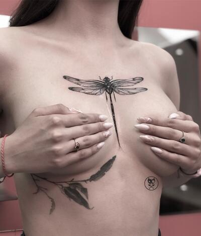 Dragonfly in between breast tattoo