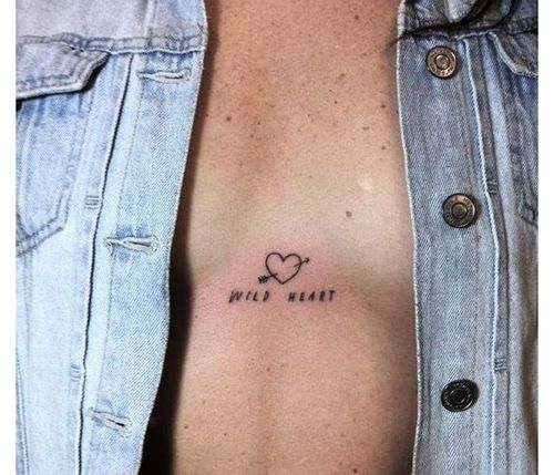 Word in between breast tattoo