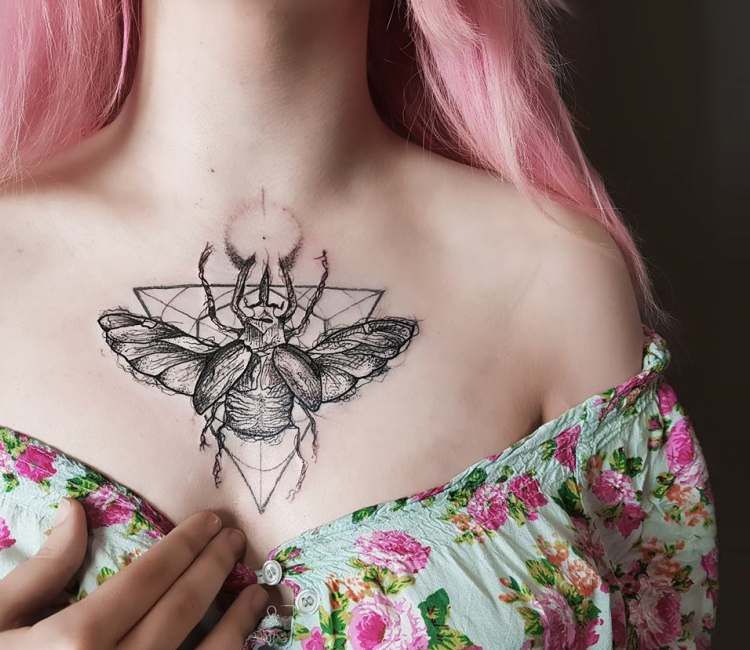 Beetle in between breast tattoo
