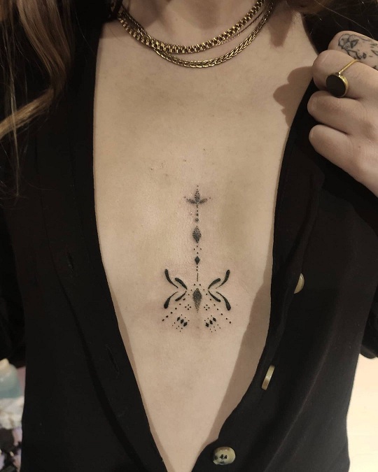 Fine line ornaments tattoo between boobs